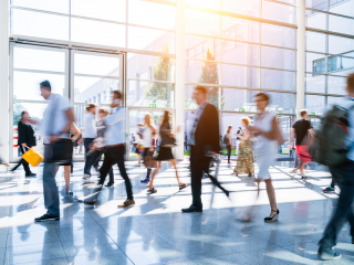 Multiple people blurred and walking through office foyer